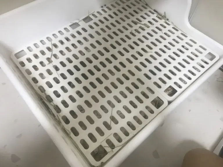 Rabbit litter box with a plastic grate cover