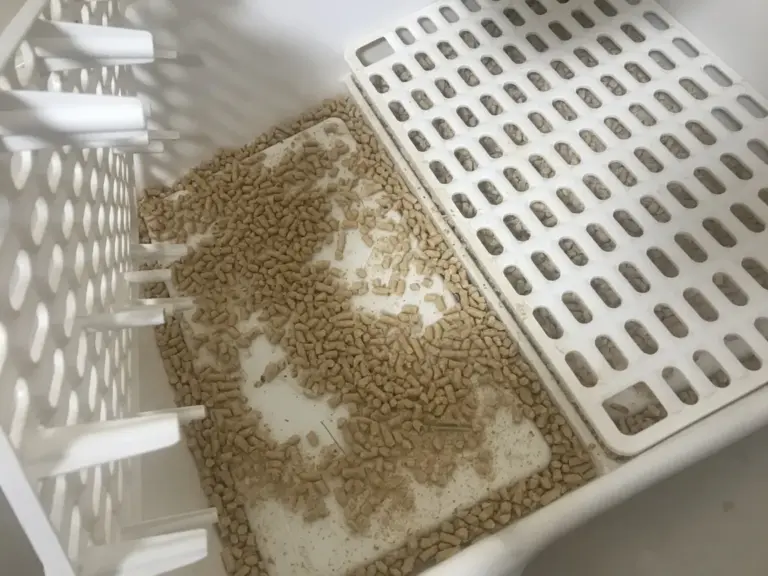 Wood pellets layered under the rabbit litter box grate