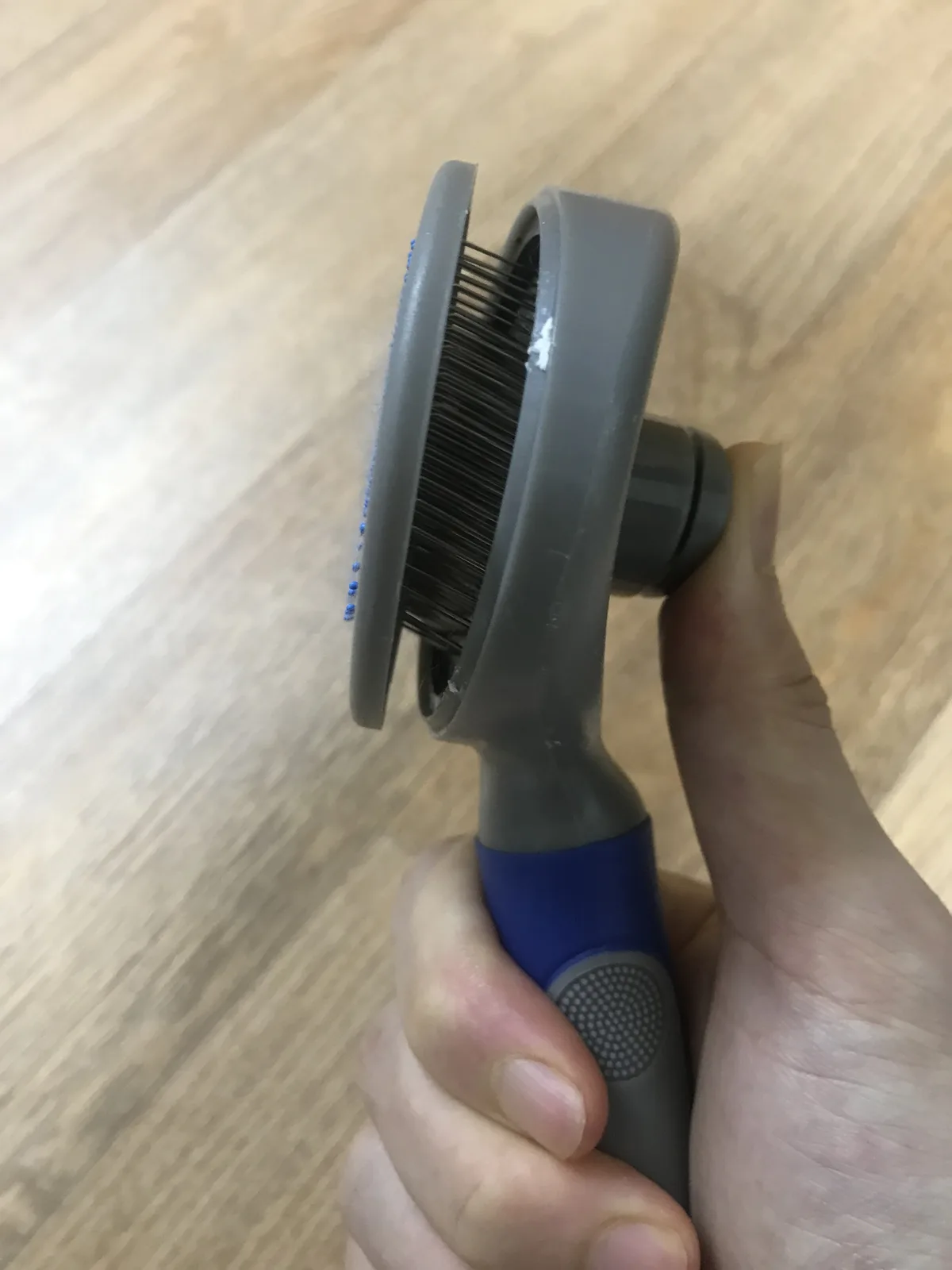 Self-cleaning slicker brush after pressing the button, base pushed out to shed the fur
