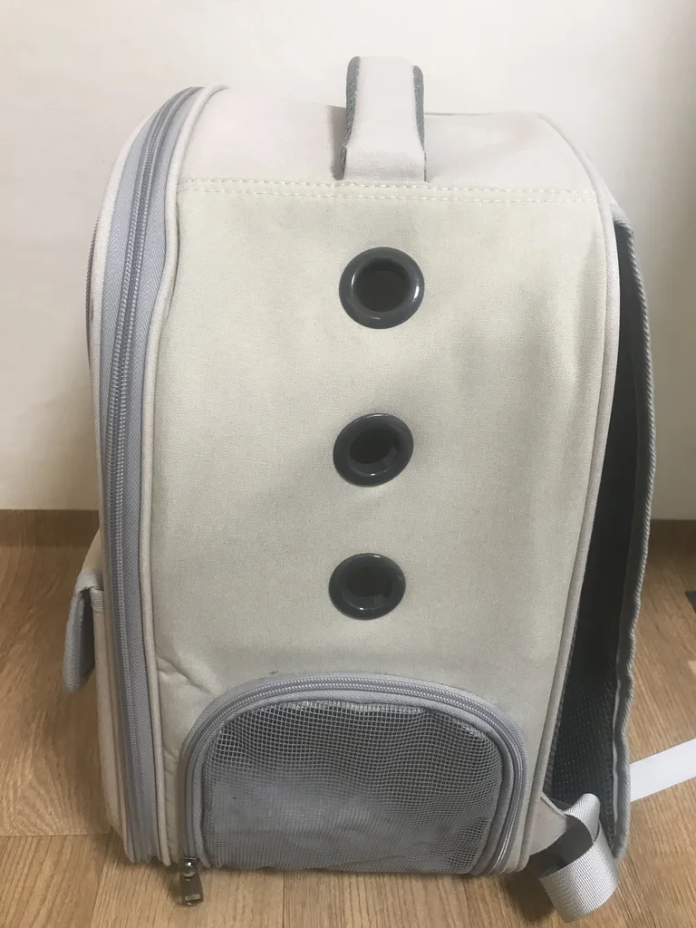 Side of the rabbit carrier with three ventilation grommets and a mesh window